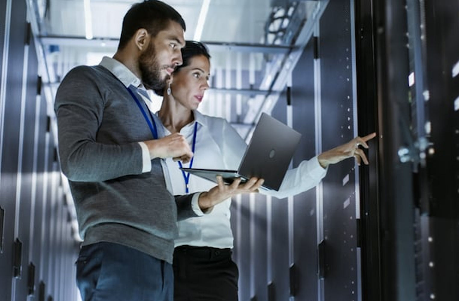RemoteOver.com offers co-managed IT services to its clients.  Client standing with RemoteOver.com Tech, the remote tech is holding a laptop looking at a server. 