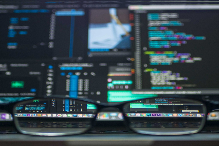 Glasses looking through a computer screen with cybersecurity info