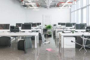 RemoteOver.com is responding on-site to a disaster in a flooded office, where several desks and computers are affected.